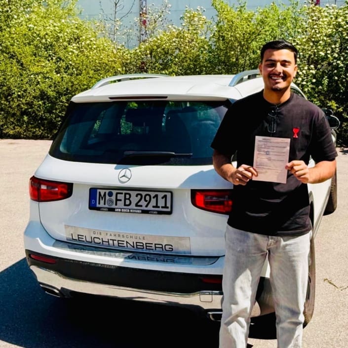 Driving student happily holds up his new driver's license for the camera - Leuchtenberg Driving School in Haidhausen, Munich