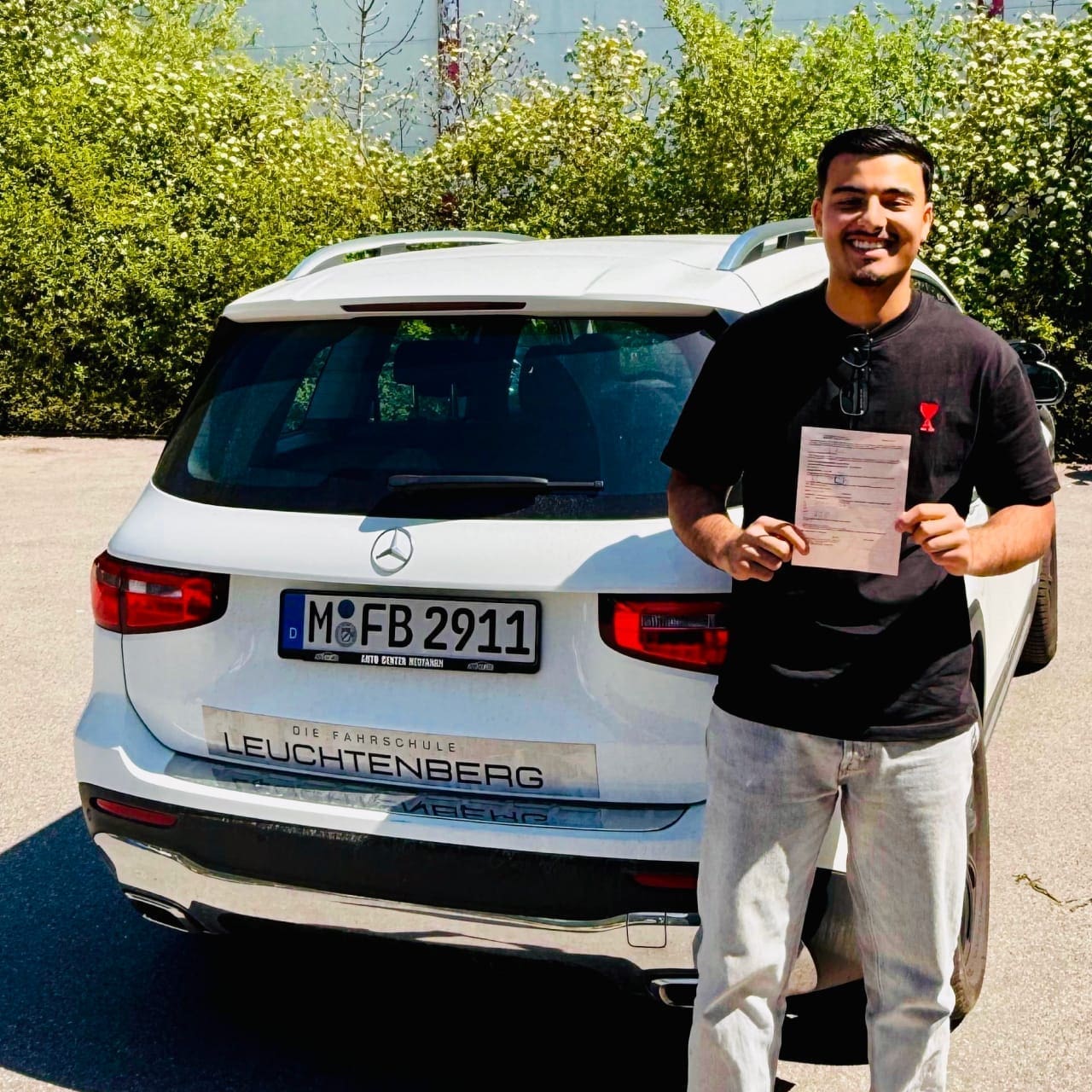 Student receives his driving license - Fahrschule Haidhausen Munich Leuchtenberg Student happily holds his new driving license - Fahrschule Leuchtenberg in Haidhausen Munich
