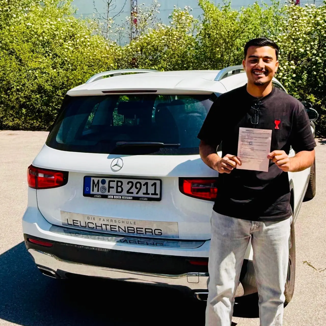 Fahrschüler hält seinen neuen Führerschein freudig in die Kamera - Fahrschule Leuchtenberg in Haidhausen München
