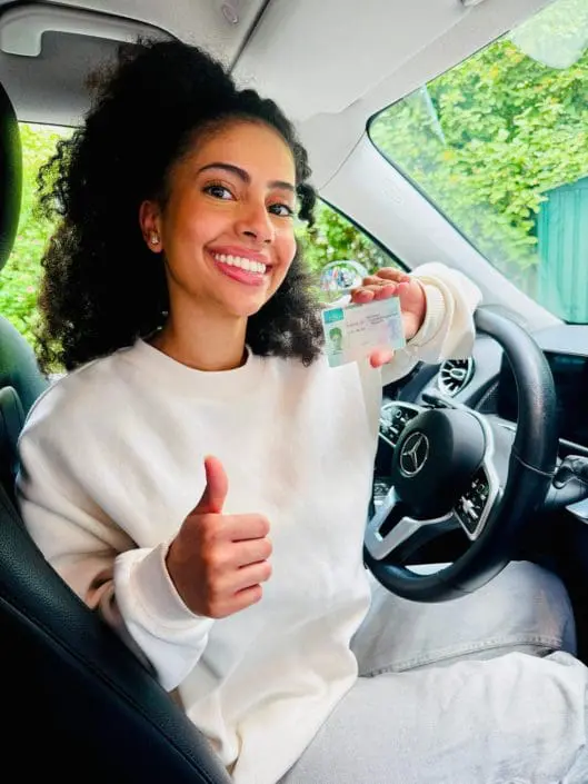 fahrschule-leuchtenberg-erfolgreiche-schuelerin-auto-alt Strahlende Fahrschülerin sitzt am Steuer und zeigt stolz ihren frisch erhaltenen Führerschein – erfolgreicher Abschluss bei der Fahrschule Leuchtenberg in München Haidhausen.
