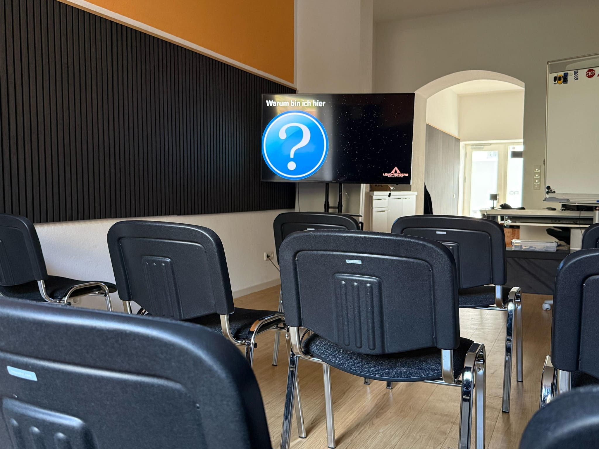 Moderner Theorieraum der Fahrschule Leuchtenberg in München – mit Stuhlreihen, Whiteboard und großem Bildschirm für interaktiven Unterricht. Raum für den theoretischen Unterricht.