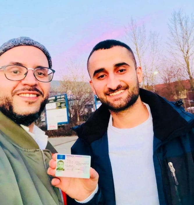 Fahrschüler erhält seinen Führerschein in München – Fahrlehrer Zoran Janjic gratuliert stolz zur bestandenen Prüfung.